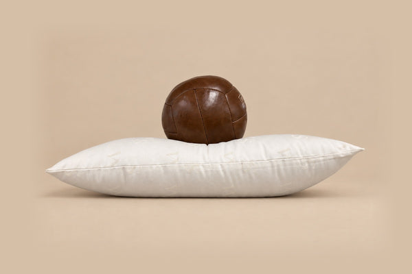 Extra Full wool pillow with a leather ball resting on it, barely sinking