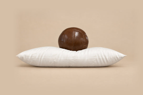Full wool pillow with a leather ball resting on it